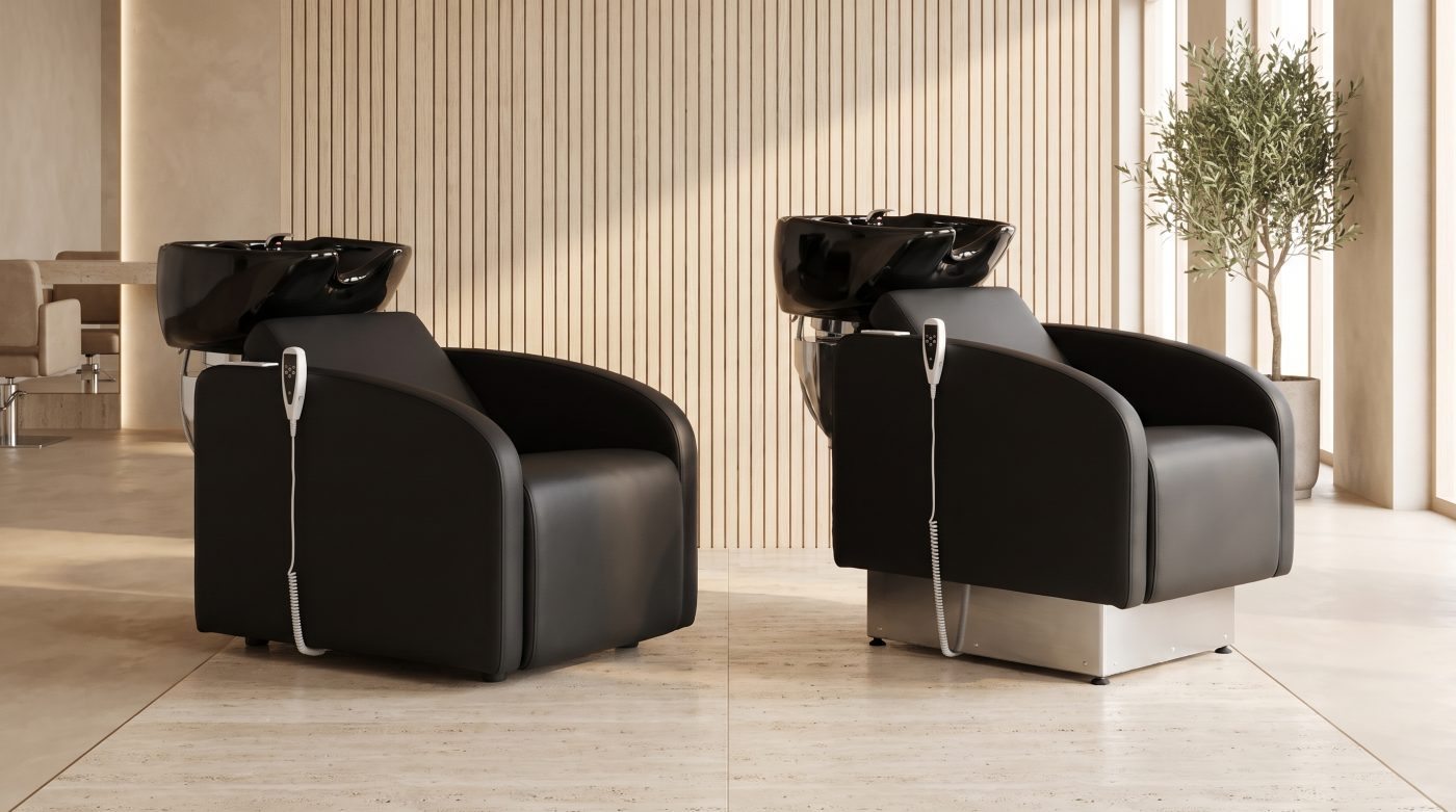 Deux bacs à shampoing LIBI LIFT installés dans un salon, vus de trois quarts : cuve céramique noire, fauteuil noir, socle inox et clavier de commande à l'accoudoir.
